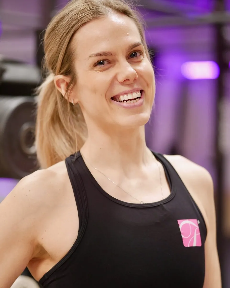 Anne Luksengård Mjelva ler, i svart singlet på treningssenteret hun leder.